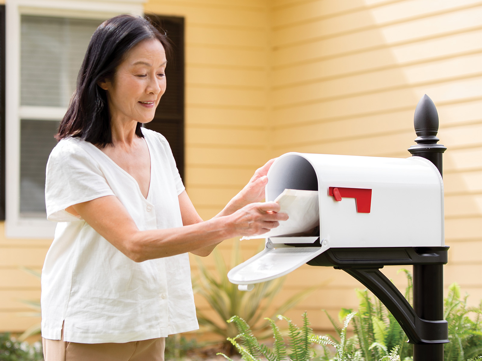 Woman removing mail from her mailbox